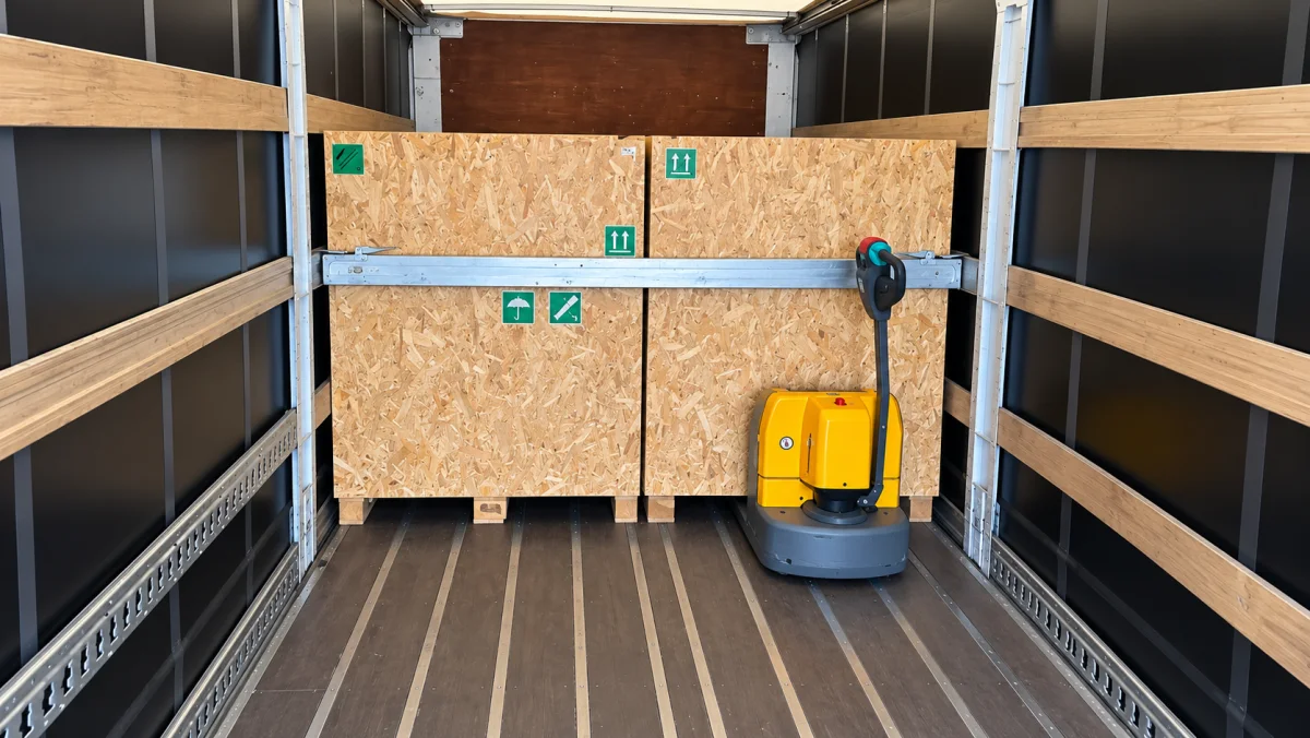 Protective wooden crates secured inside a truck for Dewar vessel dispatch