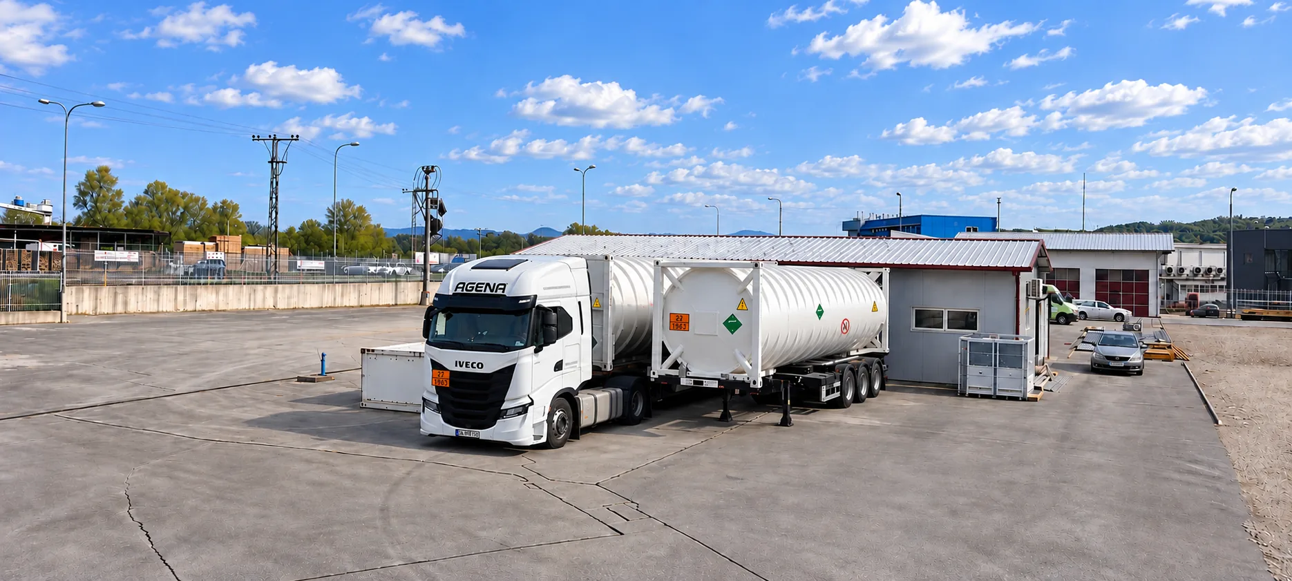 Road tractor carrying a liquid-helium ISO tank container at an industrial site